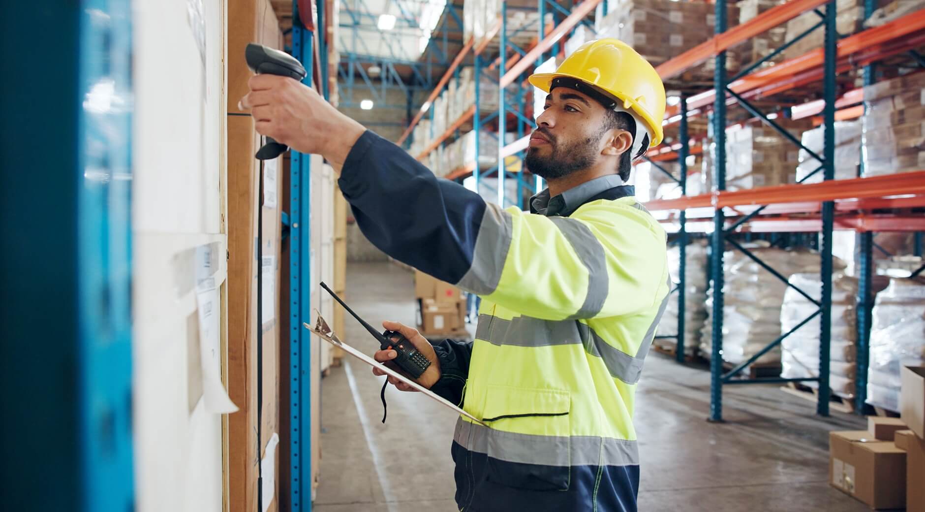 Warehouse worker in a safety vest scanning inventory barcodes in a 3PL fulfillment center