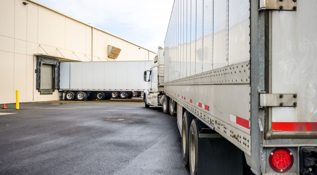 Semi trucks backed up to loading docks at a 3PL fulfillment warehouse facility